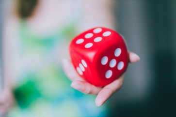 girl handing big red dice shot at shallow depth of field, concept of trying your chance at a game