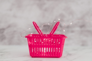 pink shopping basket with fairy lights, conceptual still-life about brilliant marketing or exciting products